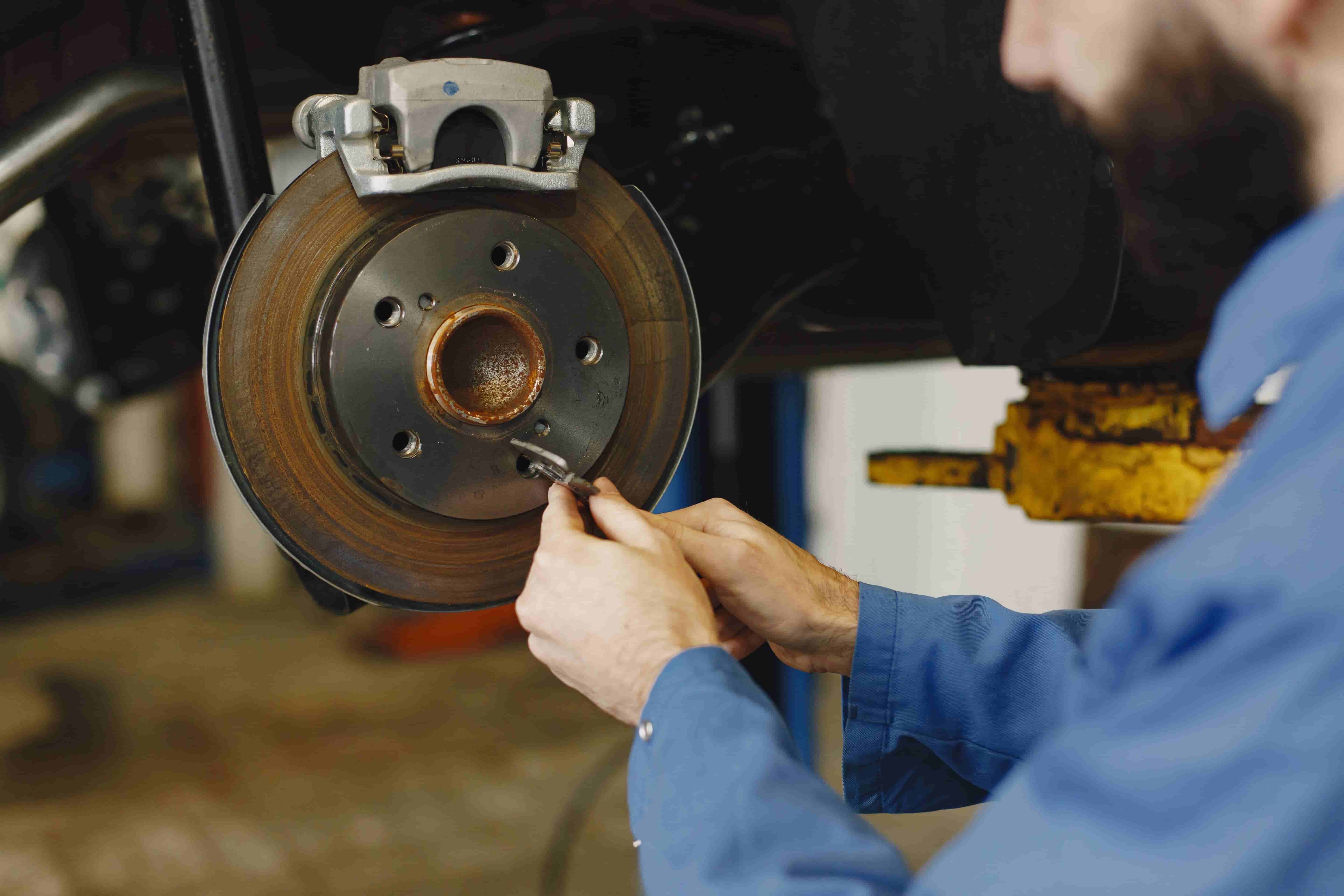 Brake rotor and caliper exposed with wheel removed during repair